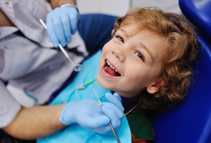 Male dentist examines a young patient